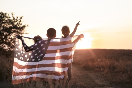 children wearing the US flag on their backs