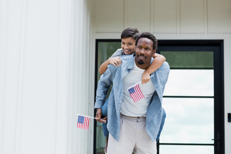 father and son holding US flags