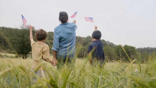 parent and children waving US flags